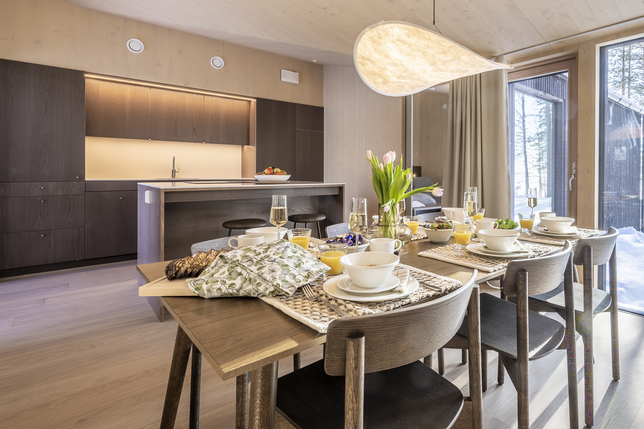 A beautifully set breakfast table in a modern kitchen featuring fresh flowers and delightful food.